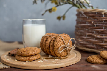homemade oatmeal cookies on a wooden tray with burlap in a rustic style. Spring composition with a basket with a willow. The concept of a home bakery, proper and healthy nutrition. Copy space for text