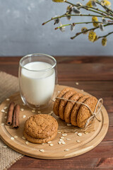 homemade oatmeal cookies on a wooden tray with burlap in a rustic style. Spring composition with a basket with a willow. The concept of a home bakery, proper and healthy nutrition. Copy space for text