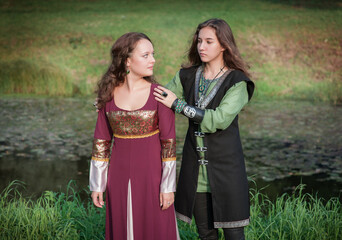 Fototapeta na wymiar Young beautiful couple in medieval style dresses outdoor