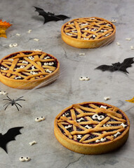 Halloween tartlet with cherry confiture, top view. Shortbread with jam, decorated with sugar bones and eyes. The bats.
