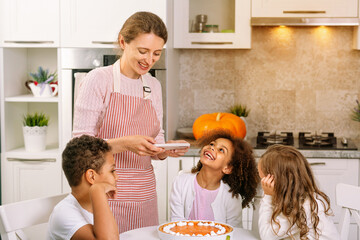 Wish you a happy Thanksgiving. The joyful children are sitting at the table. Festive dinner with family.
