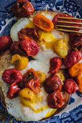 fried eggs with roasted yellow, orange, red cherry tomatoes