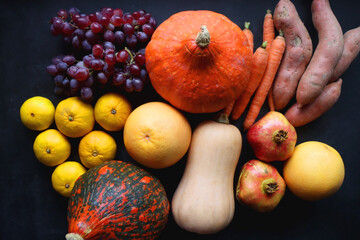 Various fresh and healthy autumnal fruit and vegetable. Top view, dark background.