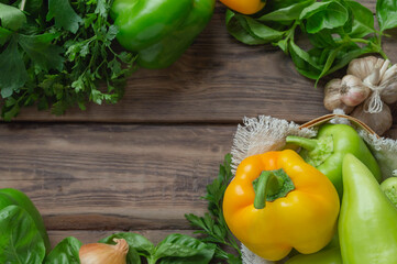 bell peppers and fresh basil, dill, parsley, cilantro, tomatoes, garlic, asparagus on a wooden table. top view. Flat lay