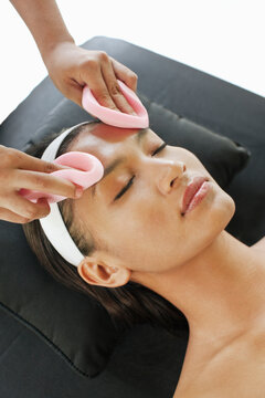Woman receiving a facial at the outdoor relaxation pavilion at a resort spa. Bali, Indonesia