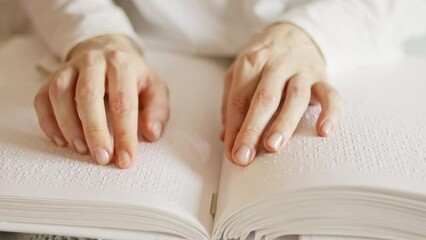 Poorly seeing woman learning Braille book. A person with blindness touches and reads with his hands.	