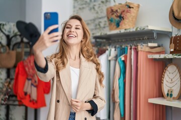 Young blonde woman customer having video call at clothing store