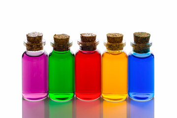 Mini glass bottles with corks filled with colored water on white background