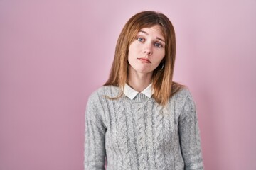 Fototapeta premium Beautiful woman standing over pink background looking sleepy and tired, exhausted for fatigue and hangover, lazy eyes in the morning.
