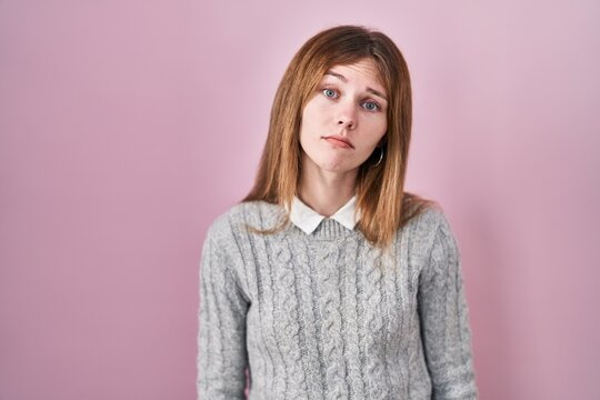 Beautiful woman standing over pink background looking sleepy and tired, exhausted for fatigue and hangover, lazy eyes in the morning.