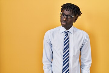 African man with dreadlocks standing over yellow background skeptic and nervous, frowning upset...