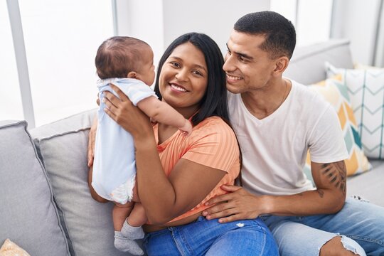 Hispanic family smiling confident sitting on sofa at home
