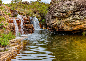 Waterfall among the vegetation and strong rocks of the Biribiri environmental reserve in Diamantina, Minas Gerais, Brazil