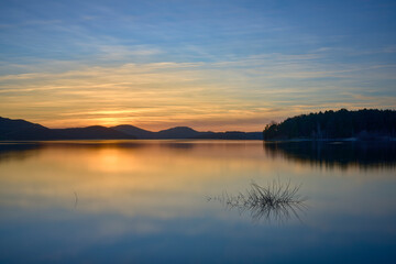 Fototapeta na wymiar Golden sunset over lake and mountains