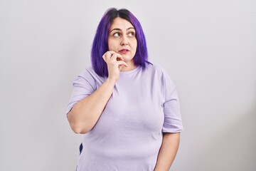 Plus size woman wit purple hair standing over isolated background with hand on chin thinking about question, pensive expression. smiling with thoughtful face. doubt concept.