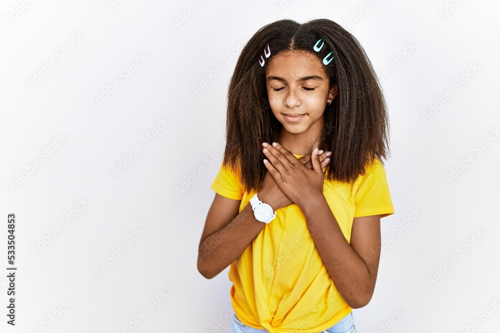 Sticker young african american girl standing over white isolated background smiling with hands on chest with