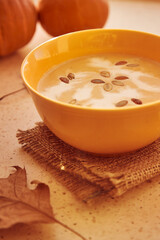 Vegetarian healthy autumn pumpkin creame-soup with seeds and plant-based cream