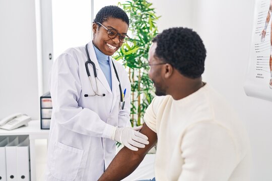 Man And Woman Doctor And Patient Putting Band Aid At Clinic