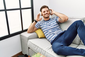 Young hispanic man smiling confident listening to music at home