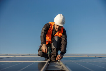 A worker is installing solar panels. - obrazy, fototapety, plakaty