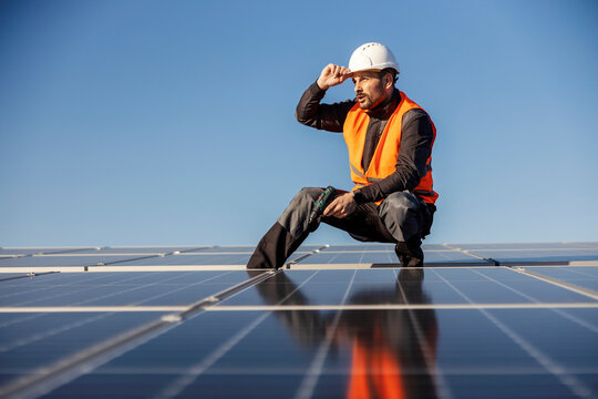 Manual worker is installing solar panels on the rooftop.