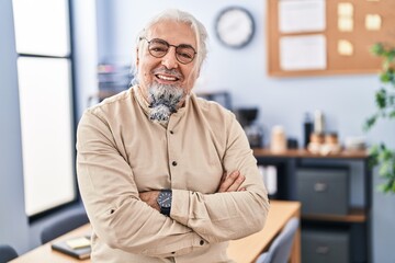 Middle age grey-haired man business worker smiling confident standing with arms crossed gesture at office
