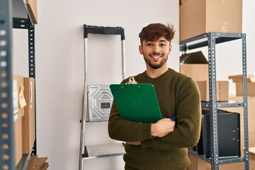 Young arab man ecommerce business worker holding checklist at office