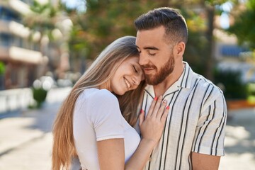 Man and woman couple smiling confident hugging each other at park