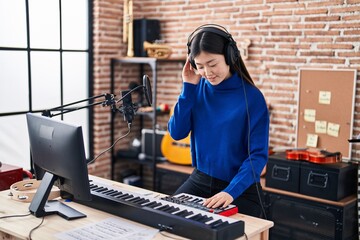 Chinese woman musician having dj session at music studio