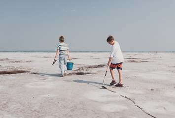 two people walking across a desolate landscape at the Great Salt Plains in Oklahoma on a family...