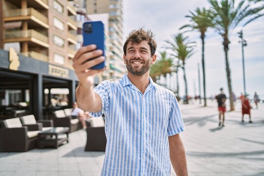 Young hispanic man smiling happy standing at the promenade.