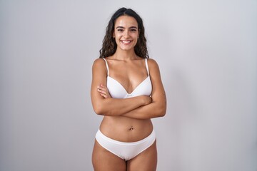 Obraz premium Young hispanic woman wearing white lingerie happy face smiling with crossed arms looking at the camera. positive person.