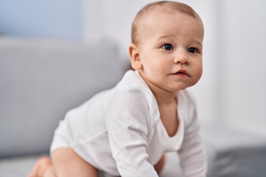Adorable toddler crowling on sofa at home