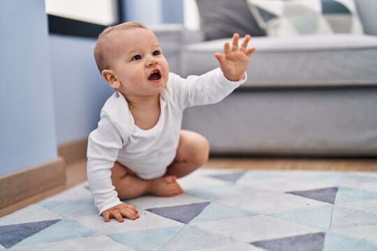 Adorable toddler crowling on floor at home