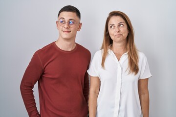 Obraz premium Mother and son standing together over isolated background smiling looking to the side and staring away thinking.