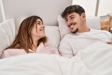 Mand and woman couple smiling confident lying on bed at bedroom