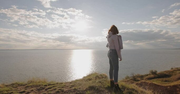 Woman discovering a wonderful view on the sea standing on a hill, this landscape is amazing