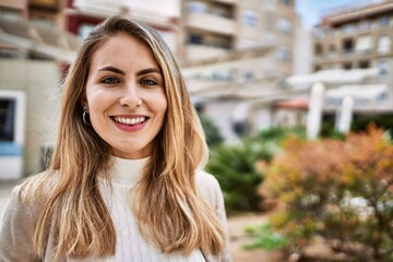 Young blonde woman smiling confident at street