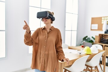 Young blonde woman smiling confident using virtual reality glasses at architect studio