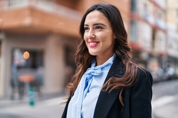Naklejka premium Young hispanic woman smiling confident standing at street