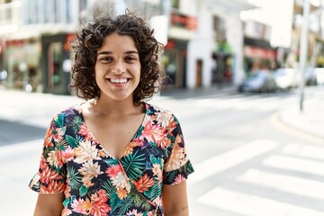 Young latin girl smiling happy standing at the city.