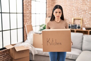 Young woman moving to a new home holding box depressed and worry for distress, crying angry and afraid. sad expression.