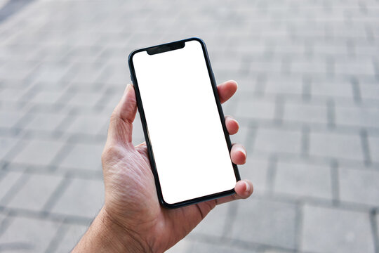 Man holding smartphone showing white blank screen at street