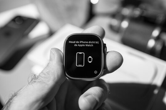 London, United Kingdom - Sep 23, 2022: bring the iPhone closer to the Apple Watch translation from Dutch houd de iPhone dicht bij de apple watch during setup of new titanium Apple Watch Ultra 