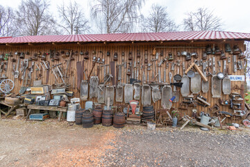 Old rusty tools and home equipment hanging on the barn wall.