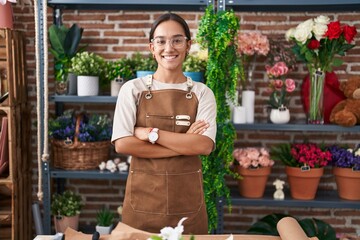 Young beautiful hispanic woman florist smiling confident standing with arms crossed gesture at...
