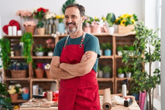 Middle age man florist smiling confident standing with arms crossed gesture at florist
