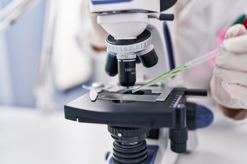 Young woman scientist using microscope working at laboratory