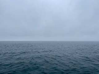 calm ocean with horizon and gray clouds