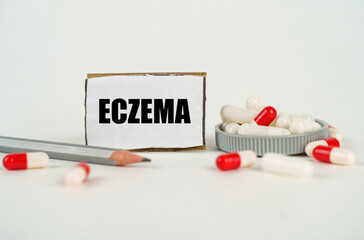 On a white background, medical capsules, a pencil and a cardboard plate with the inscription -...